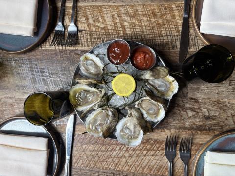 Oysters plate ready to eat placed on top of a table.